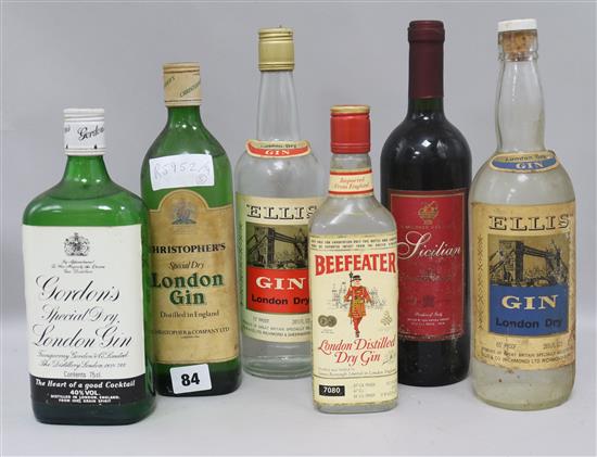 Five assorted bottles of gin including Christophers Gordons and Ellis and a bottle of red wine.